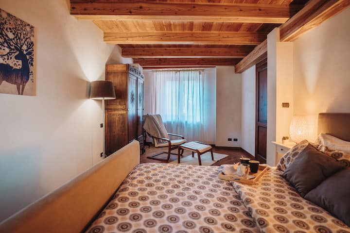 Dhomë gjumi e madhe me krevat dopio dhe ambient çlodhjeje me karrige të gjatë