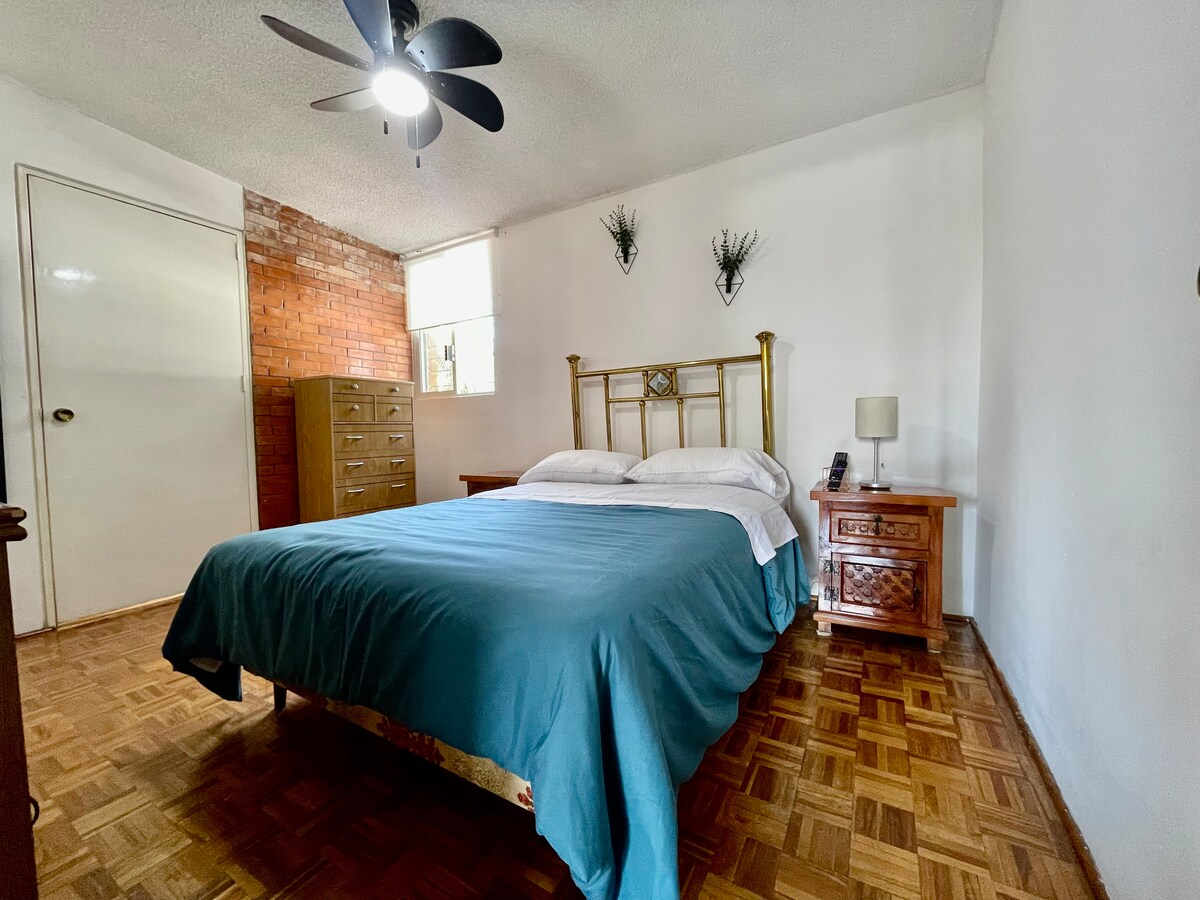 Სასტუმრო ოთახი ორადგილიანი საწოლითა და ტელევიზორით