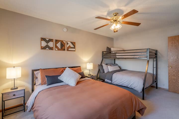 Designed with groups and families in mind, this versatile bedroom features a cozy queen bed, a twin-over-full bunk bed, and warm decorative touches throughout, plus a TV for relaxing movie nights.