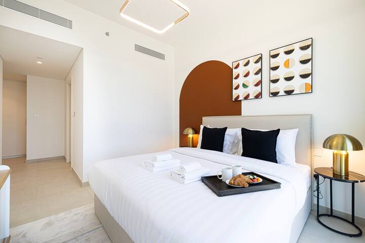 להירגע בחדר השינה הראשי המרווח עם מיטה מפוארת בגודל קינג סייז וחלונות מהרצפה עד התקרה המציגים נופים פנורמיים של מרכז העיר דובאי.  