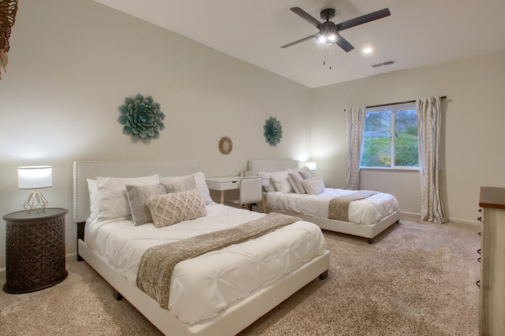 Spavaća soba s dva bračna kreveta s fleksibilnim rasporedom spavanja i udobnim prostorom za goste.