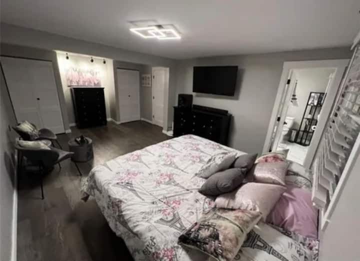 Comfortable bedroom with a king bed, tv, dresser, and cozy seating area. A relaxing private space to unwind after a day of swimming, exploring, or enjoying time with family and friends.
