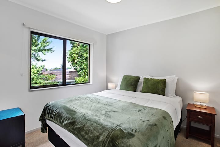 第二间卧室配有漂亮的绿色和垫子，可将室外带入室内。