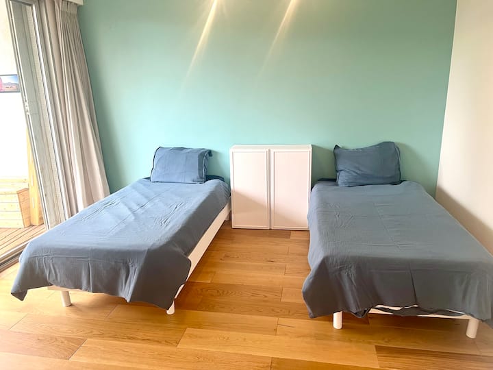 חדר שינה עם 2 מיטות יחיד המשקיפות על המרפסת