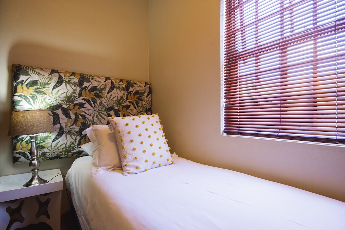 Спална соба со единечен кревет и доволно простор за облека во гардероберот.