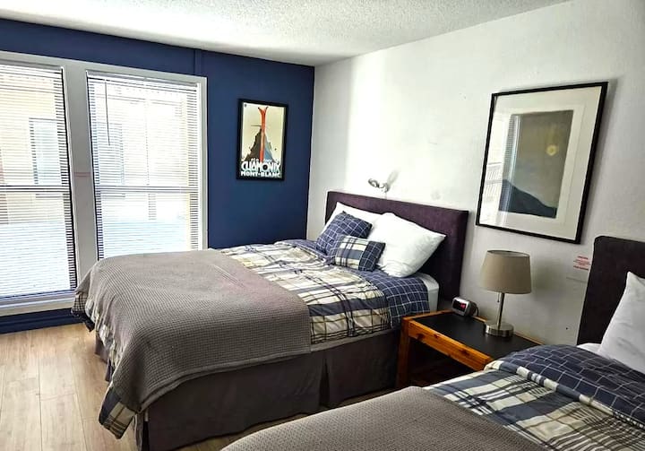 Grande et spacieuse chambre principale avec deux lits doubles et salle de bain principale complète et espace de rangement.