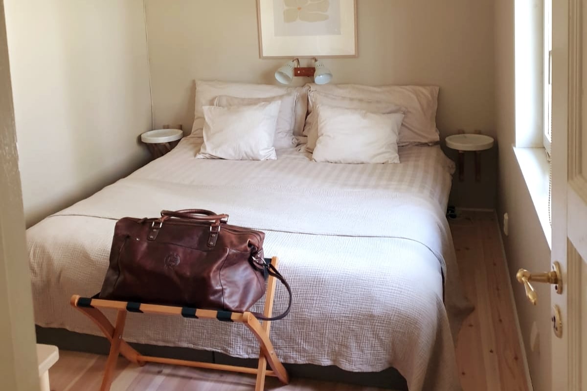 חדר שינה שליו, שליו ומבודד עם מיטה זוגית גדולה בדגם יבשתי. מקום אחסון הולם לבגדים ולספסל מזוודות.