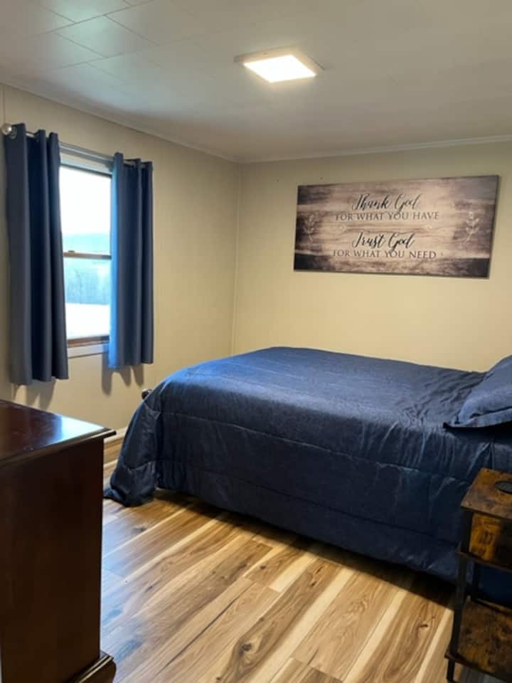 تقع غرفة النوم 1 في الطابق الأول.  طاولتان ليليتان، إحداهما تحتوي على محطة شحن مع منافذ كهربائية ومنافذ يو إس بي.