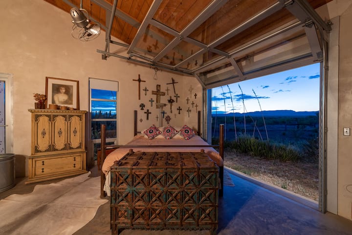 Maaster bedroom at dusk with the garage door open