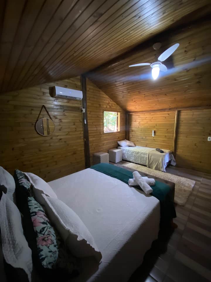 Quarto com cama de casal e cama de solteiro, com ar-condicionado.