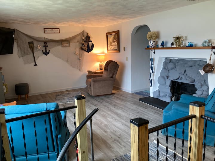 Stambeni prostor na katu. LED televizor i naslonjači. Spiralne stepenice do prizemlja.