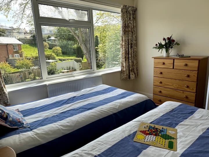 Bedroom Two with chest of drawers and view of neighbouring properties beyond the garden.