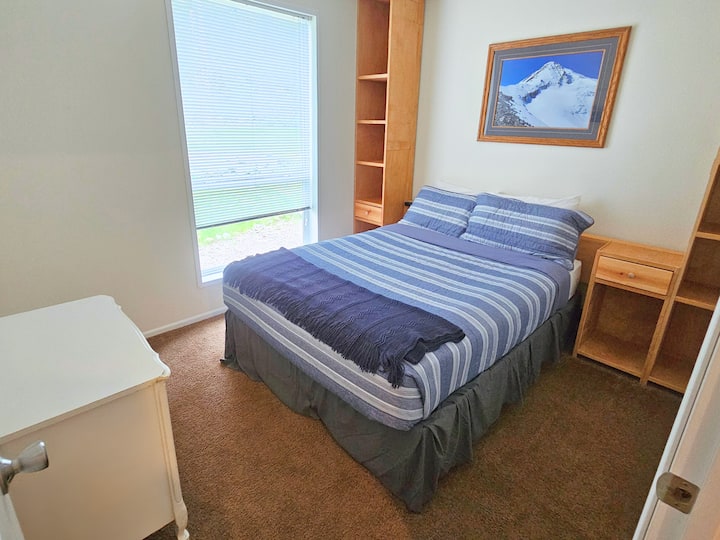 تحتوي غرفة النوم المريحة ذات الطابع الأزرق مع سرير بحجم كوين مريح على رفوف مدمجة لتخزين الكثير من التخزين. استخدم المكتب الصغير والخزانة مع شماعات لمتعلقاتك الشخصية.