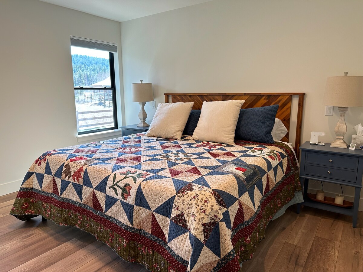 Dhomë gjumi kryesore me banjë të bashkangjitur. Pamje e hangarit dhe arenës. Hyrje në verandë.