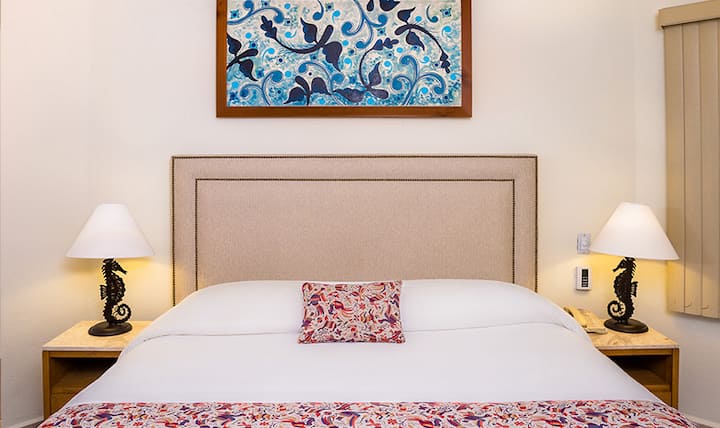 Çlodhu në ambientin e qetë të dhomës së gjumit të Vilës del Palmar, të zbukuruar me art vendas dhe komoditete prej pelushi.