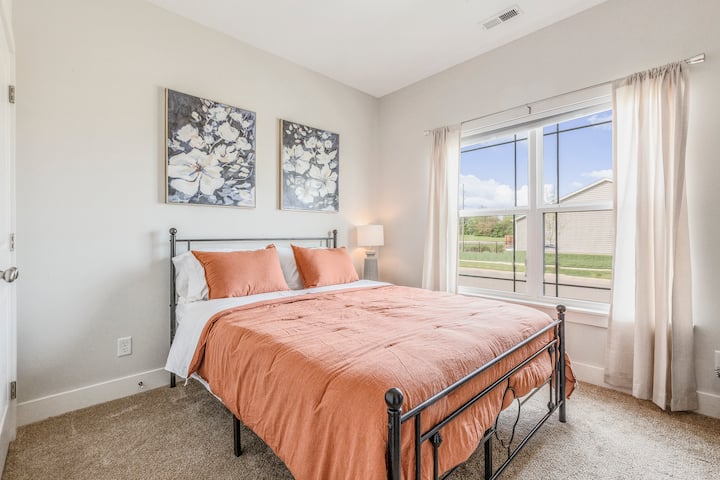 The 2nd bedroom has a queen size bed, 40" smart TV, and ample closet space with wooden hangers.