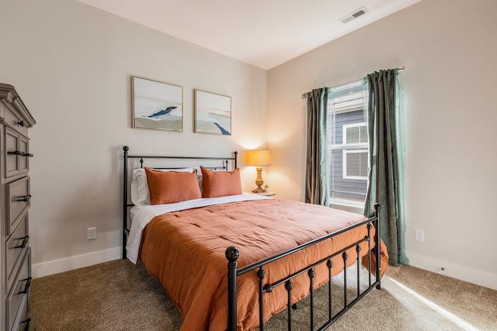 The 3rd bedroom has a queen size bed, 40" smart TV, and ample closet space with wooden hangers.