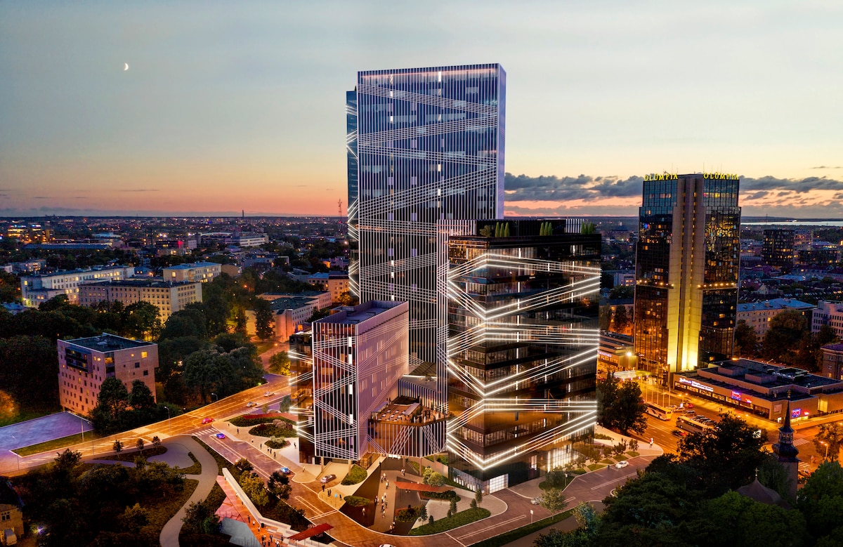A modern building complex is displayed, featuring sleek, illuminated architectural designs. The structures are surrounded by greenery and open spaces, set against a backdrop of a sunset sky. Nearby urban development and city lights enhance the contemporary ambiance of the area.