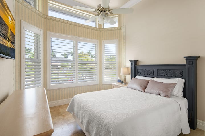 第三间卧室配有标准双人床、吊扇、智能电视、带天鹅绒衣架的衣柜和两个行李架。