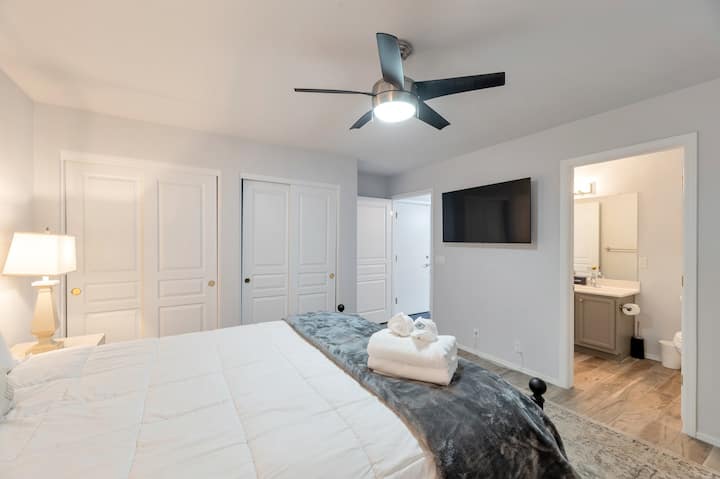 Spálňa na prízemí s manželskou posteľou Queen, inteligentnou televíziou a vlastnou kúpeľňou.