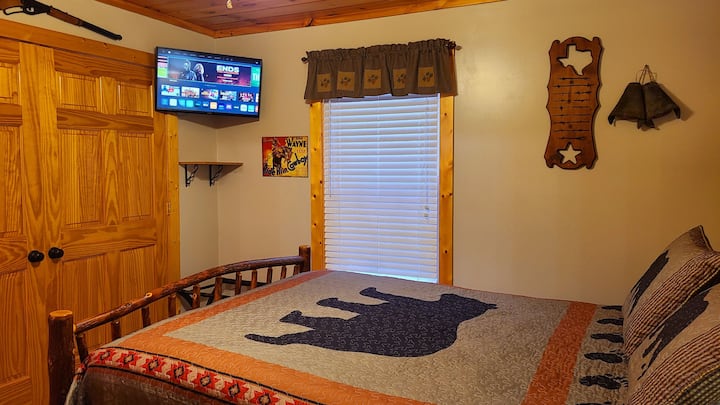 Spálňa na hlavnom poschodí so západnou tematikou s manželskou posteľou a 32-palcovým INTELIGENTNÝM televízorom. Priľahlá kúpeľňa s vaňou/sprchou.