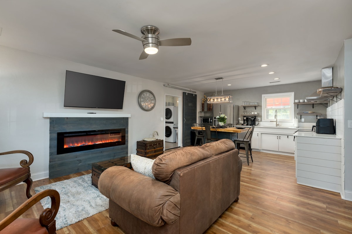 Удобна дневна соба, отворена кон кујната. Опремено со електронски камин, кожен кауч за седење, две кожни столици, телевизор со рамен екран, уред за стриминг Roku и ретро масичка за кафе.