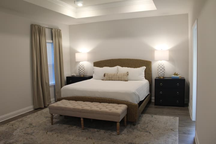 غرفة النوم الرئيسية الأولى (سرير كينج مع تلفزيون ذكي وخزانة ملابس وحمام داخلي مع حوض استحمام ودش ومنضدة تزيين مزدوجة وخزانة كبيرة)