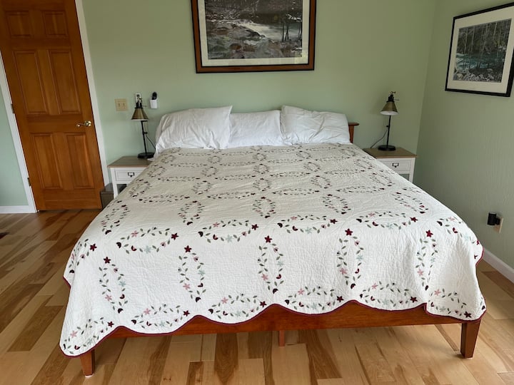 מיטת קינג סייז חדשה ונוחה בקליפורניה עם עמדות טעינה שנבנו לתוך שידות הלילה, סדינים איכותיים ושמיכת טלאים מכוסים בשמיכת פוך. 
