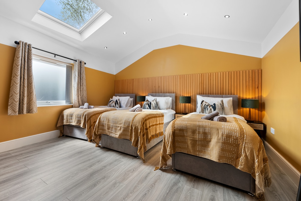 Удобна спална соба со 3 единечни кревета со премиум постелнина, ноќна масичка и топол абажур - совршен за мирен ноќен сон во Blue Puffin Stays Short Lets & Serviced Accommodation.