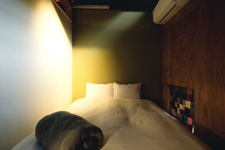 Კომპაქტური ოთახი ორადგილიანი საწოლითა და პატარა მაგიდით.
Ნათელი სივრცე, სადაც ჭერის სინათლიდან მზის სხივებს იგრძნობთ.