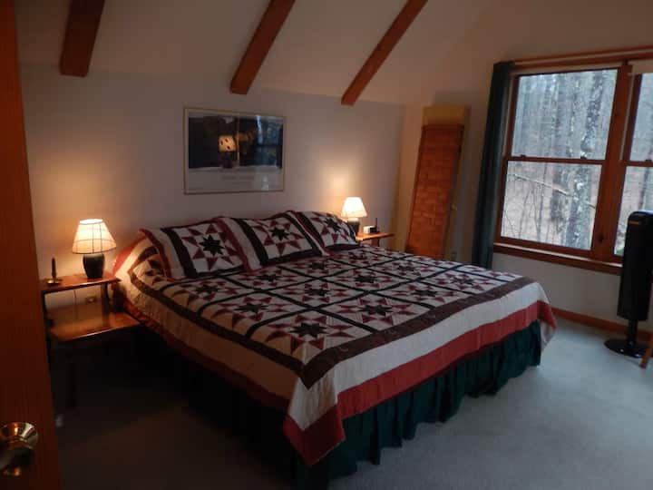 Manželská posteľ King s výhľadom na jazero cez strešné okná.