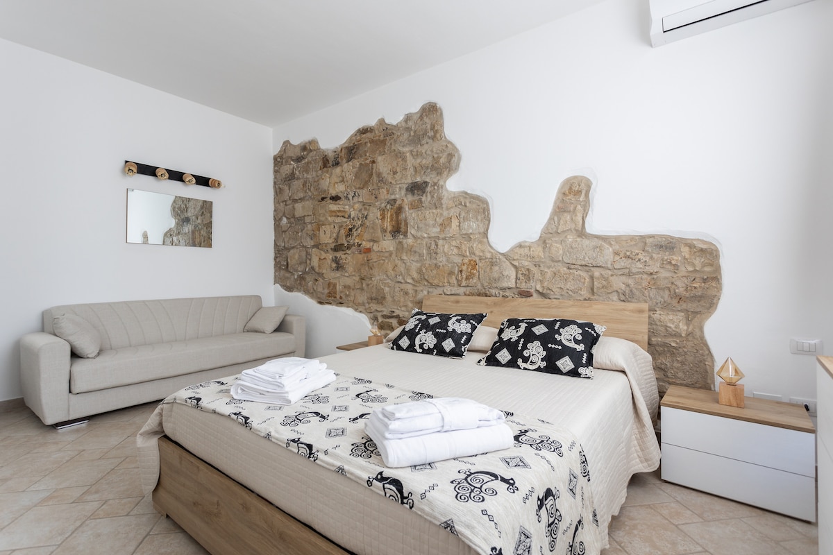 Grote, lichte slaapkamer in Sardijnse stijl met een slaapbank. 
