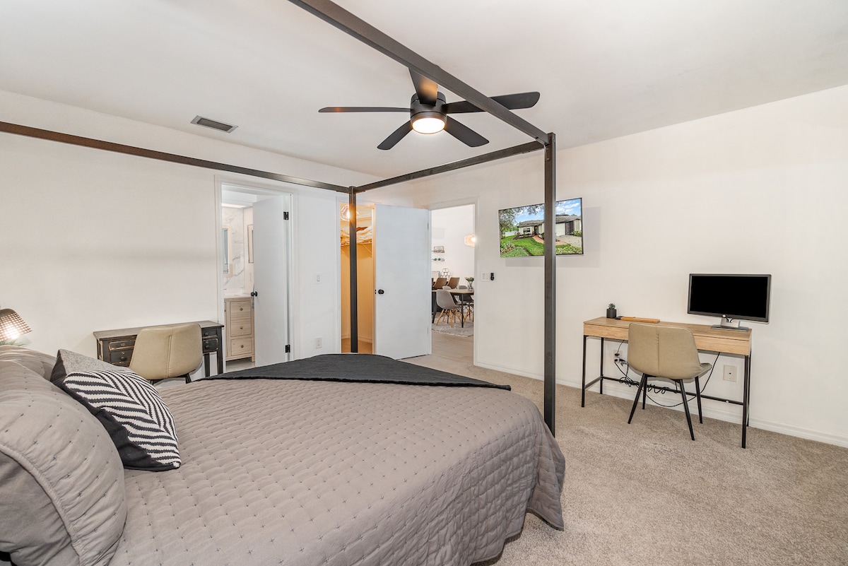 Bedroom Retreat: Relax in style with a sleek four-poster bed and modern workspace!
