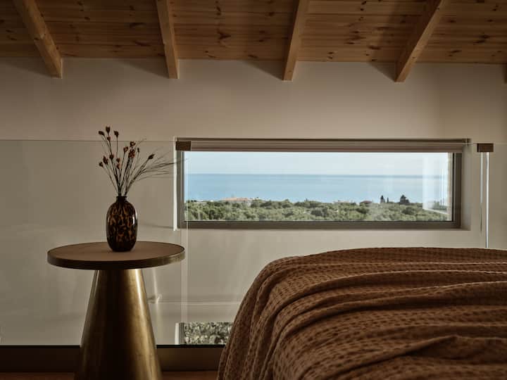 Slaapkamerinstellingen op de tussenverdieping (kingsize bed) gelegen op de 2e verdieping, met uitzicht op zee. 