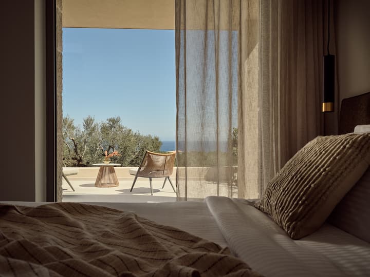 Slaapkamer met tweepersoonsbed op de eerste verdieping, balkon met uitzicht op zee. 