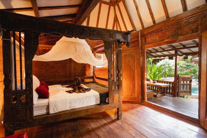 Izba „Indra“ má krásnu starožitnú posteľ so štyrmi stĺpikmi, pracovným stolom a terasou s výhľadom na bazén.