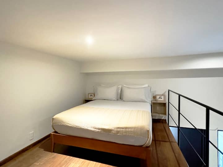 Este dormitorio se encuentra en un entresuelo sobre el área de la televisión.

Tiene una cama tamaño queen y su propio espacio de almacenamiento. Se accede a través de una escalera vertical (que se muestra en fotos anteriores). 

Asegúrate de que los usuarios de este espacio tengan una movilidad segura.