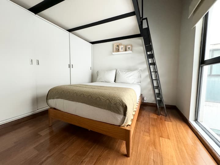 Las camas de esta habitación están separadas por un entrepiso. En el nivel inferior hay una cama individual y una tamaño queen en el nivel superior.

Ambos niveles tienen su propio espacio de almacenamiento.

Ten en cuenta que se accede al nivel superior por las escaleras que se muestran en la foto.