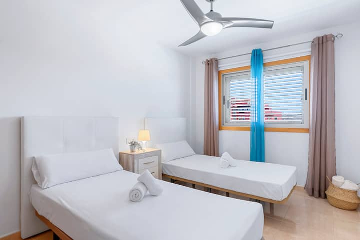 Segundo dormitorio con camas individuales y ventilador de techo.