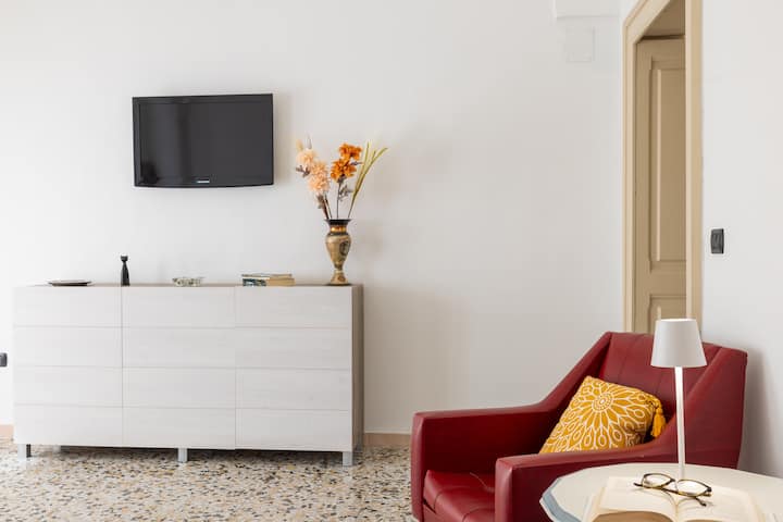 ห้องนั่งเล่นสว่างสดใสตกแต่งด้วยเตียงโซฟาคู่ที่สะดวกสบายและทีวี LED UHD ที่ทันสมัย