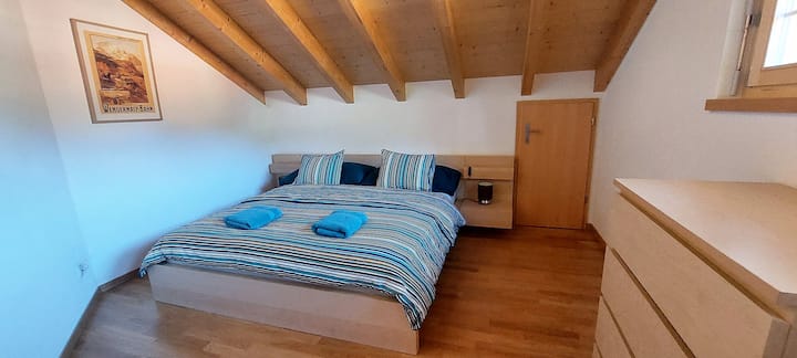 Iznimno veliki krevet u spavaćoj sobi.  Veliki garderober i set crteža.