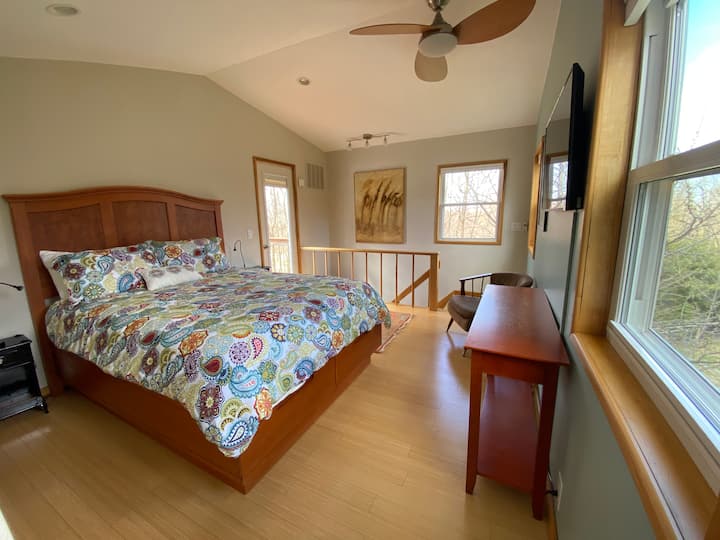 Master bedroom on the third floor with queen bed, twin bed nook, half bath and balcony.
