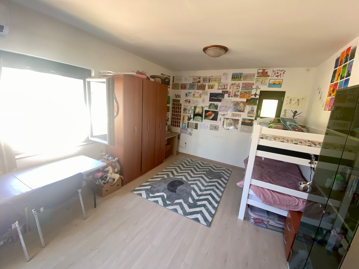 Kjo dhomë gjumi është shumë e madhe dhe zakonisht dyfishohet si dhomë gjumi dhe dhomë lojërash për 2 vajza. Një sërë bunksesh, plus hapësirë në dysheme për dyshekë nëse nevojitet. Oh, dhe ka verandën e vet të vogël.
Kondicioneri Samsung Whisper ofron ftohje dhe ngrohje.