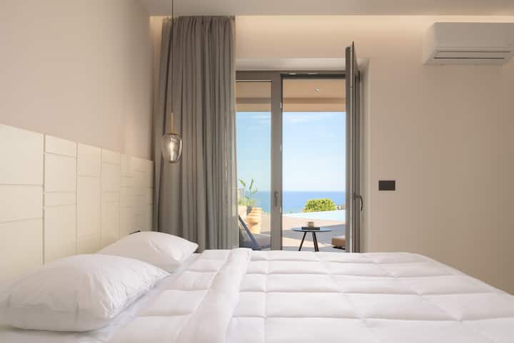 Spálňa s manželskou posteľou, ktorá sa nachádza na prízemí, má priamy prístup na terasu pri bazéne.