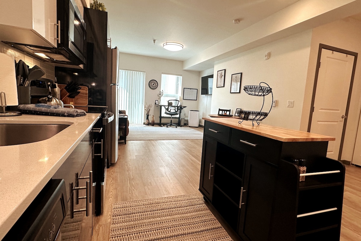 Fully equipped kitchen overlooking the open living area and dedicated workspace—perfect for preparing meals, relaxing, or working remotely.