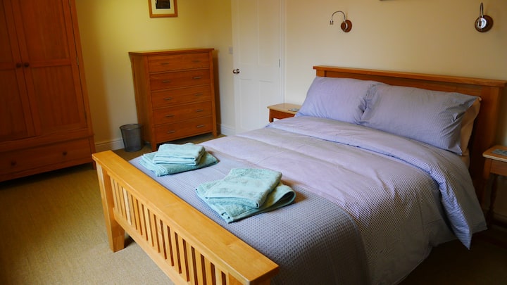 Წინა მთავარი საძინებელი ორადგილიანი საწოლით, გარდერობითა და უჯრის გულმკერდით. Სრული სიგრძის სარკე და ფენი.