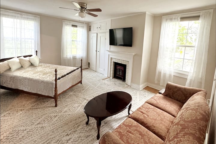 The "bridal suite" is a large bedroom with a full sized bed and connects to the en-suite bathroom with two sinks, a shower, and a modern clawfoot tub. 