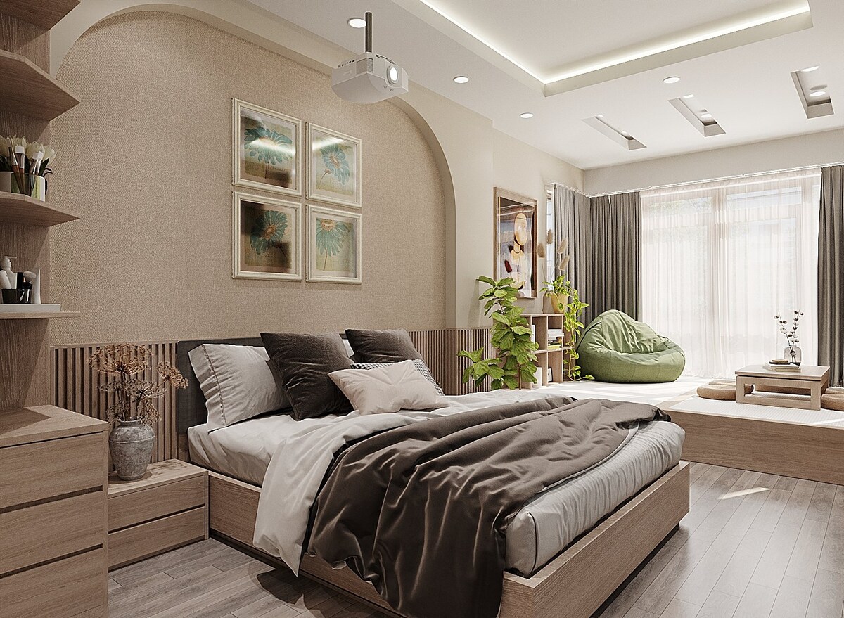 A serene bedroom features a spacious bed with soft linens and a mix of dark and light pillows. A large window allows natural light to fill the room, complemented by a cozy reading nook with a green chair and decorative plants.