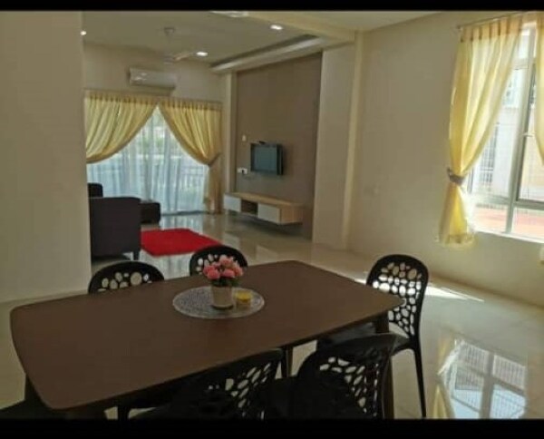 A modern living space features a dining table surrounded by six black chairs. A comfortable sofa is positioned nearby, with a television mounted on a light wooden unit. Large windows allow natural light to fill the room, complemented by soft yellow curtains.