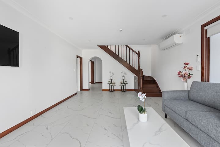 Vstúpte do priestranného luxusu a otvorte dvere do rozsiahlej obývacej izby Airbnb. Táto obývacia izba sa bezproblémovo pripája k priestoru na poschodí a do priľahlého kancelárskeho/obývacieho priestoru, ktorý ponúka pohodlie a flexibilitu počas celého svojho pobytu.